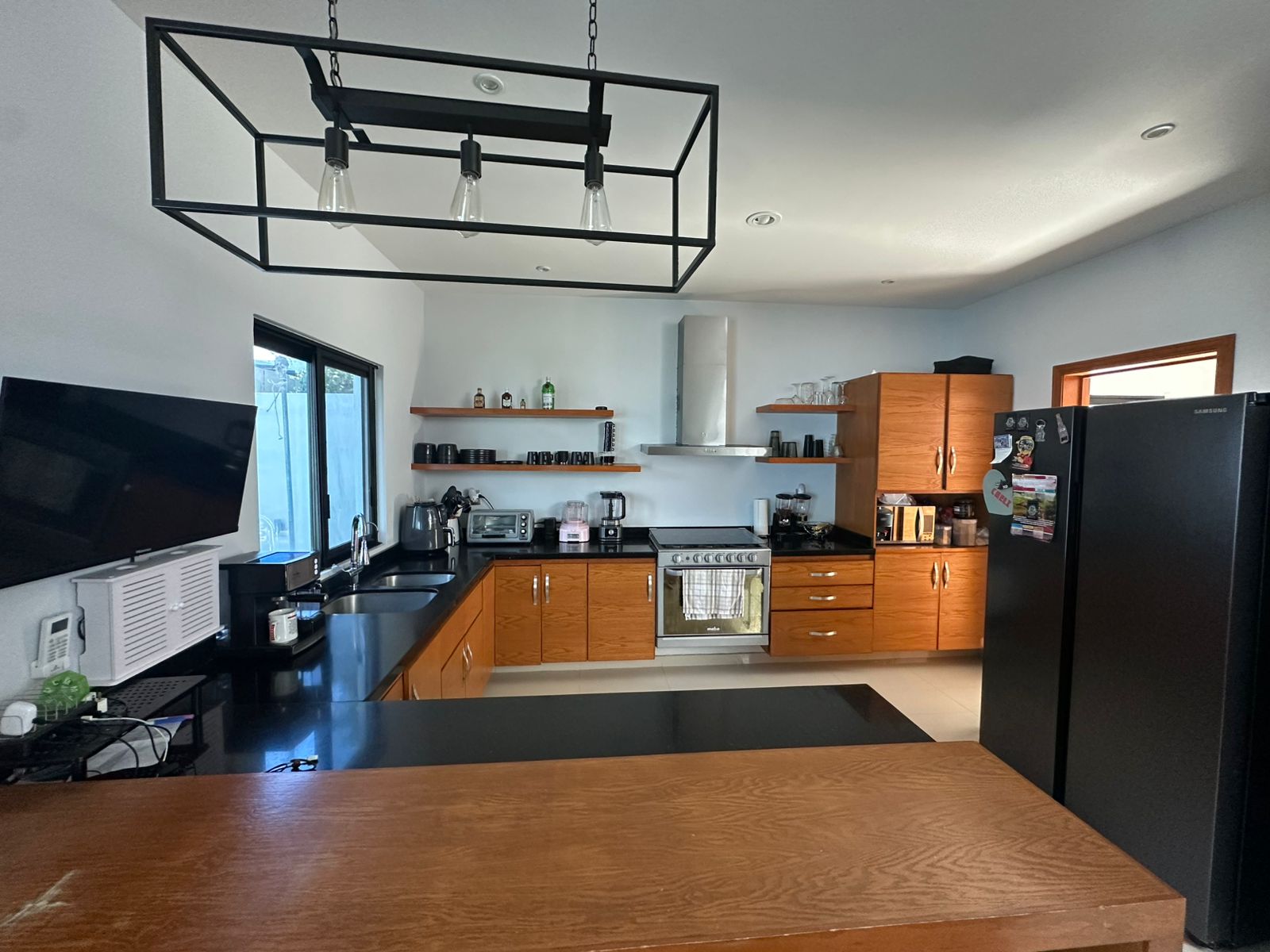 Cocina moderna con gabinetes de madera y cubiertas oscuras